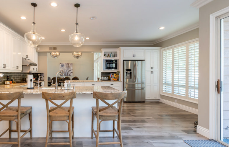 A kitchen with wooden floors and white cabinets.